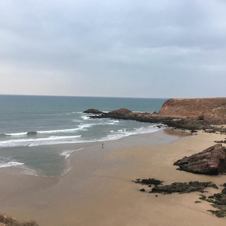 Wellen, Strand und Felsen an der Küste von Mirleft, Marokko