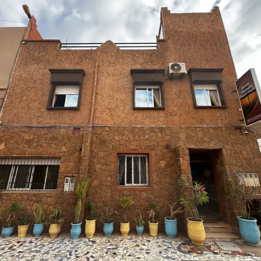 Fassade des Apartment Tayought Mirleft mit Pflanzen und rustikalem Stil.