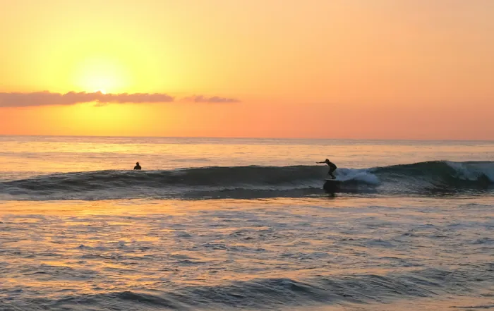 Abendstimmung am Meer mit Surfer im Wasser – Karma Surf Camp Mirleft